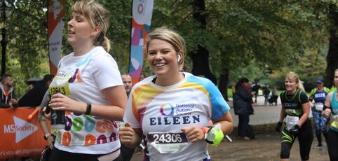 Two people smiling and running.